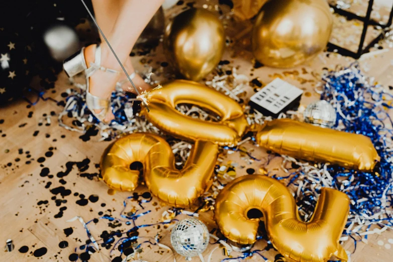 a table topped with gold balloons and confetti, by Julia Pishtar, trending on unsplash, letter s, holding a gold bag, college party, background image