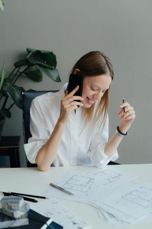 a woman sitting at a table talking on a cell phone, designer product, very consistent, architect, ekaterina