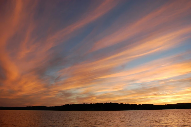 a large body of water with a sunset in the background, by Susy Pilgrim Waters, hurufiyya, ceremonial clouds, lachlan bailey, minn, nature photo