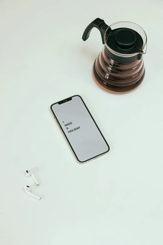 a phone sitting on top of a table next to a cup of coffee, trending on pexels, hypermodernism, design on a white background, messages, low quality photo, wireless headphone stand