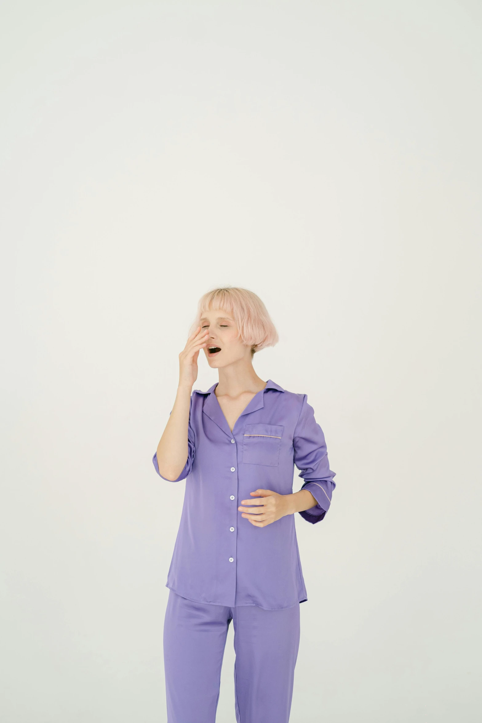 a woman in a purple shirt and pants talking on a cell phone, an album cover, trending on pexels, sleepy fashion model face, yawning, very pale, sleepwear