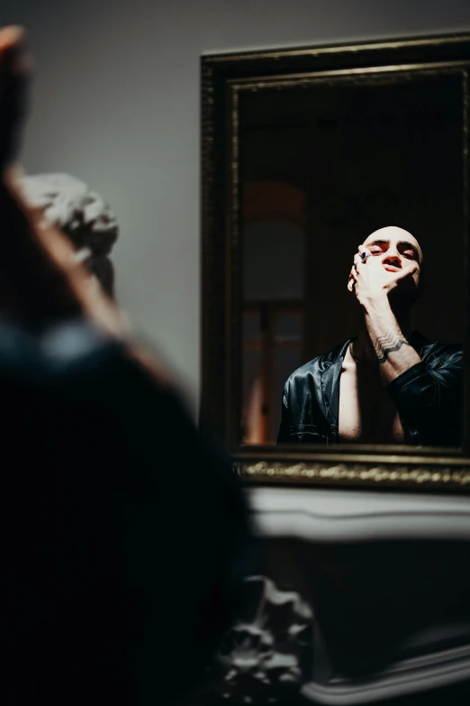 a man taking a picture of himself in a mirror, a photo, inspired by Elsa Bleda, pexels contest winner, visual art, shaved bald head, wearing goth makeup, profile image, evening time