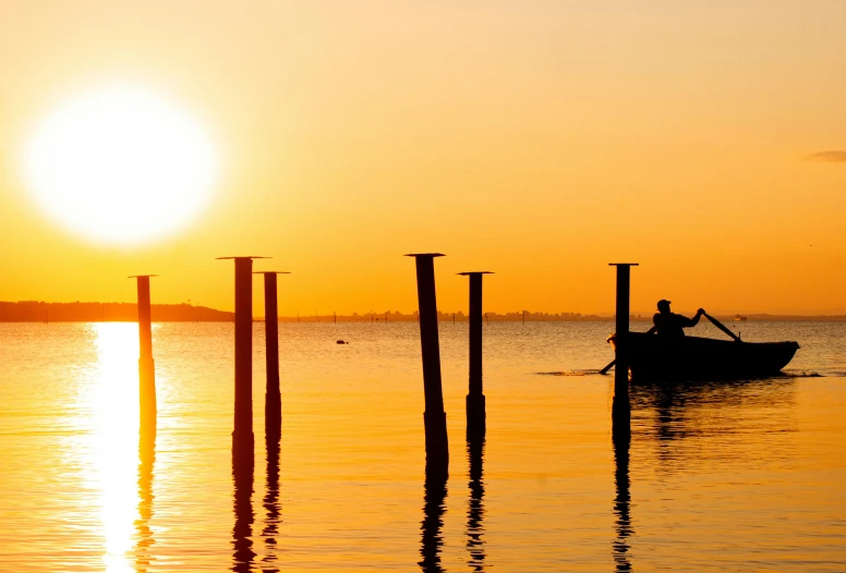 a person in a boat on a body of water, by Carey Morris, pexels contest winner, romanticism, golden sunlight, near a jetty, silhouetted, slide show