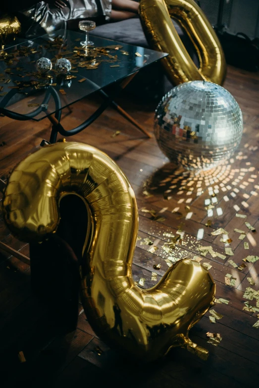 a table topped with gold balloons and confetti, pexels contest winner, reflective floor, letter s, dj at a party, trending on vsco