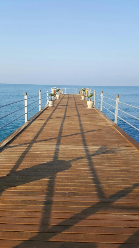 a wooden pier stretching out into the ocean, by Marcello Bacciarelli, casting long shadows, cyprus, 15081959 21121991 01012000 4k, morning detail