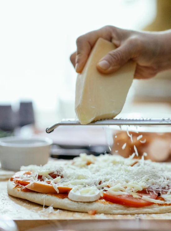 a person putting cheese on top of a pizza, by Julia Pishtar, slide show, spatula, full product shot, mason