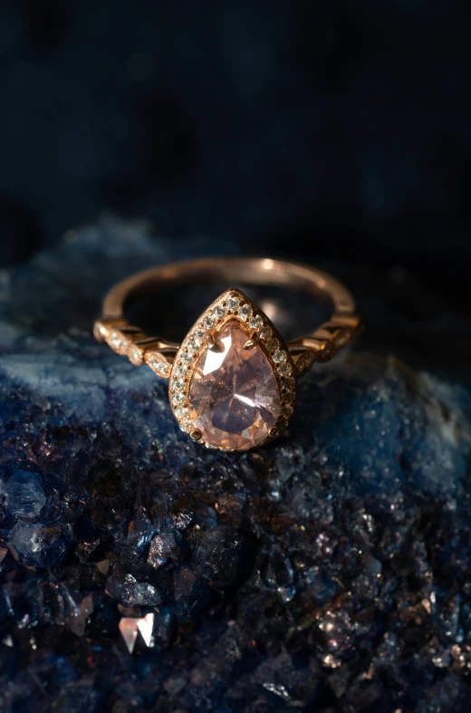 a close up of a ring on a rock, by Jessie Algie, renaissance, tear drop, rose tones, thumbnail, hero shot