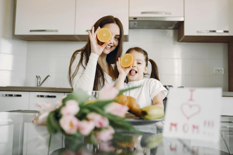 a woman and a little girl sitting at a table with oranges, pexels contest winner, 🦩🪐🐞👩🏻🦳, cute kitchen, avatar image, 1 4 9 3