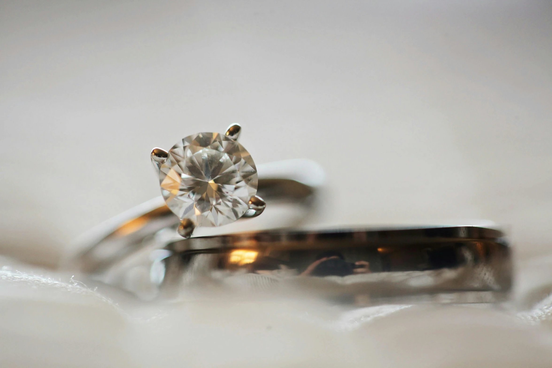 a couple of wedding rings sitting next to each other, a macro photograph, by Julian Allen, trending on pixabay, minimalism, diamond, silver，ivory, brown, faceted