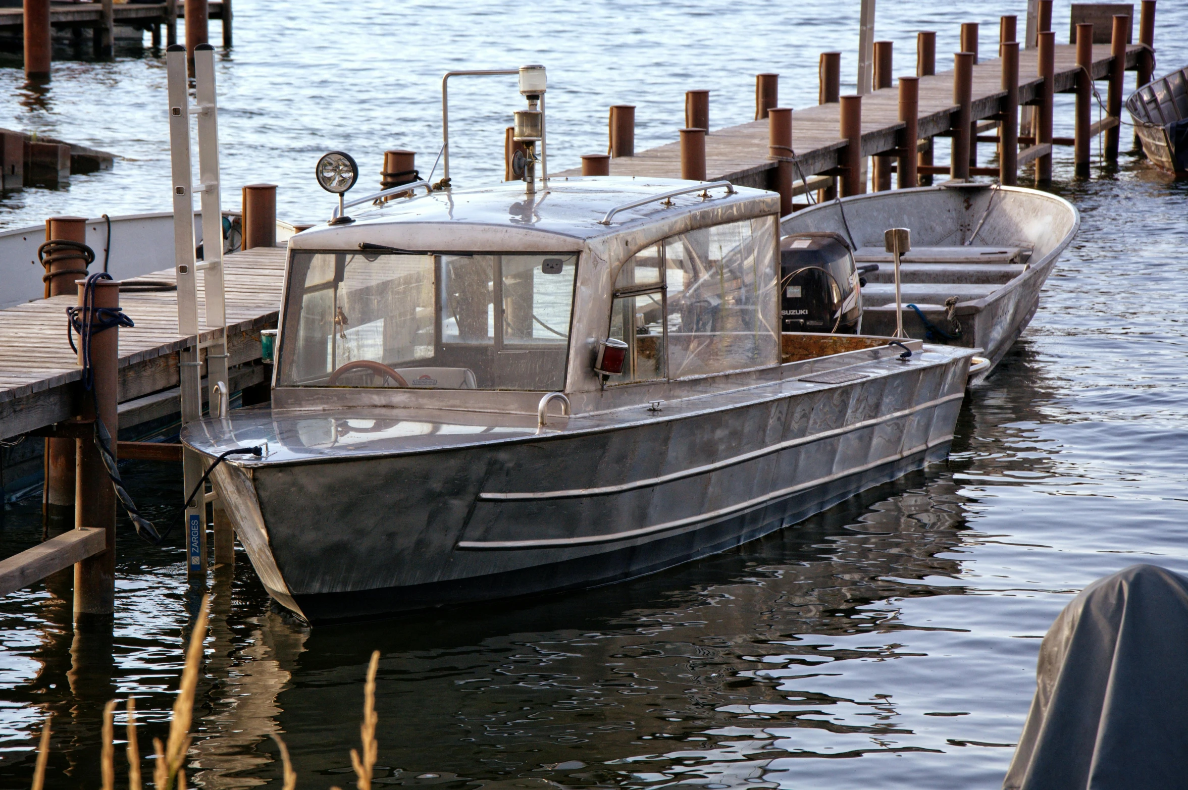 a couple of boats that are sitting in the water, grey metal body, 2022 photograph, nostalgic 8k, city docks