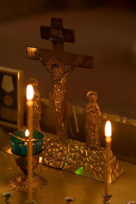 a group of candles sitting on top of a table, crucifix, the three marys at the sepulchre, golden glow, on ship