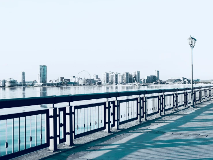 a man riding a skateboard down a sidewalk next to a river, pexels contest winner, hurufiyya, osaka skyline background, bridges and railings, jeddah city street, a photo of a lake on a sunny day