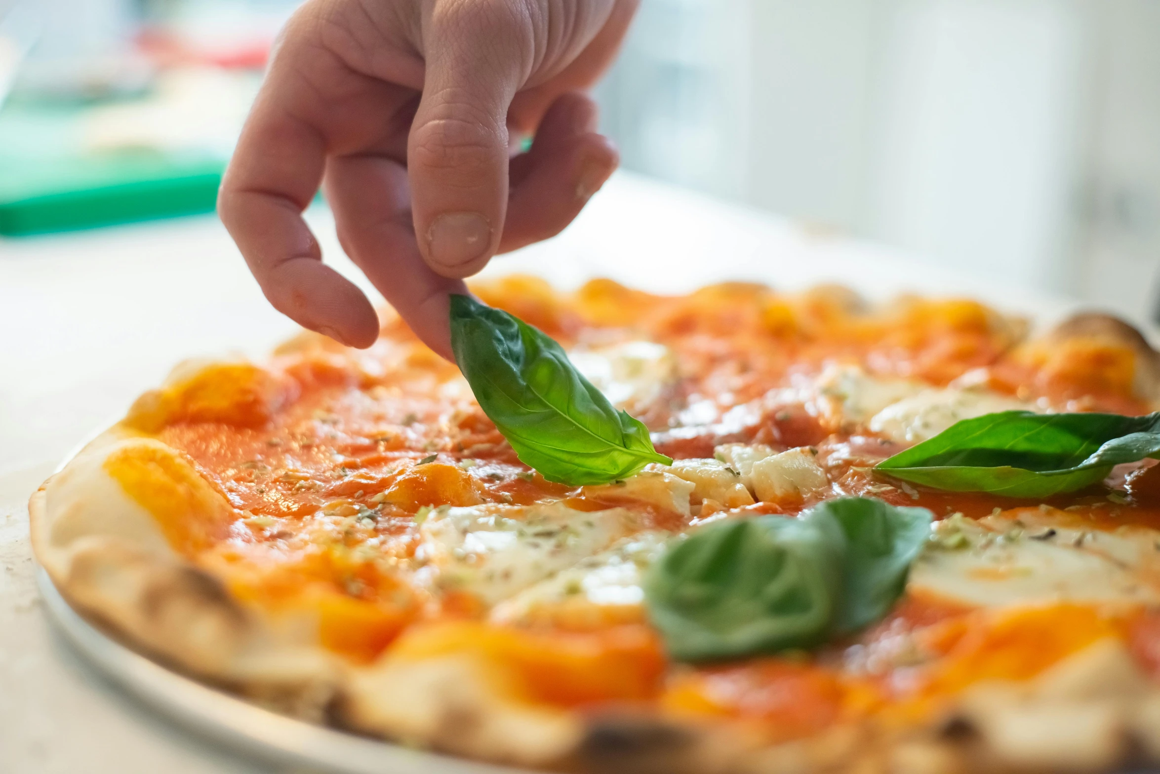 a close up of a person putting a leaf on a pizza, profile image, naples, back towards camera, pointing