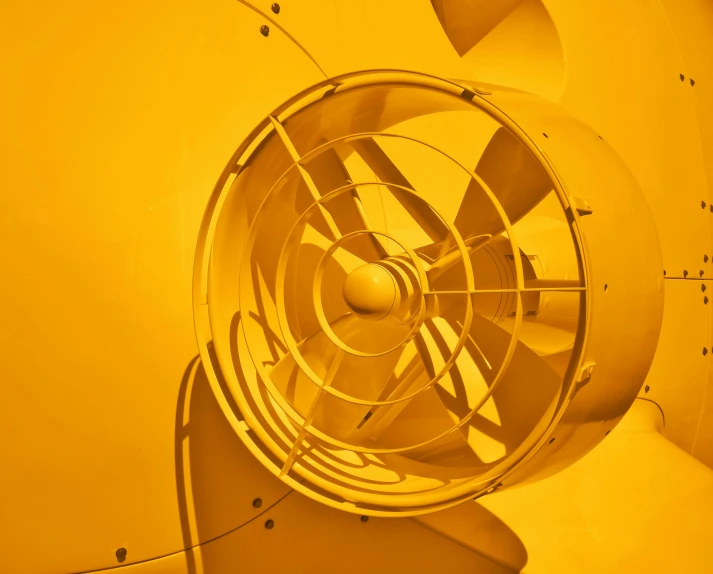 a close up of a fan on a wall, by Thomas Häfner, pexels contest winner, kinetic art, yellow hue, autodesk inventor, nuclear waste, promo image