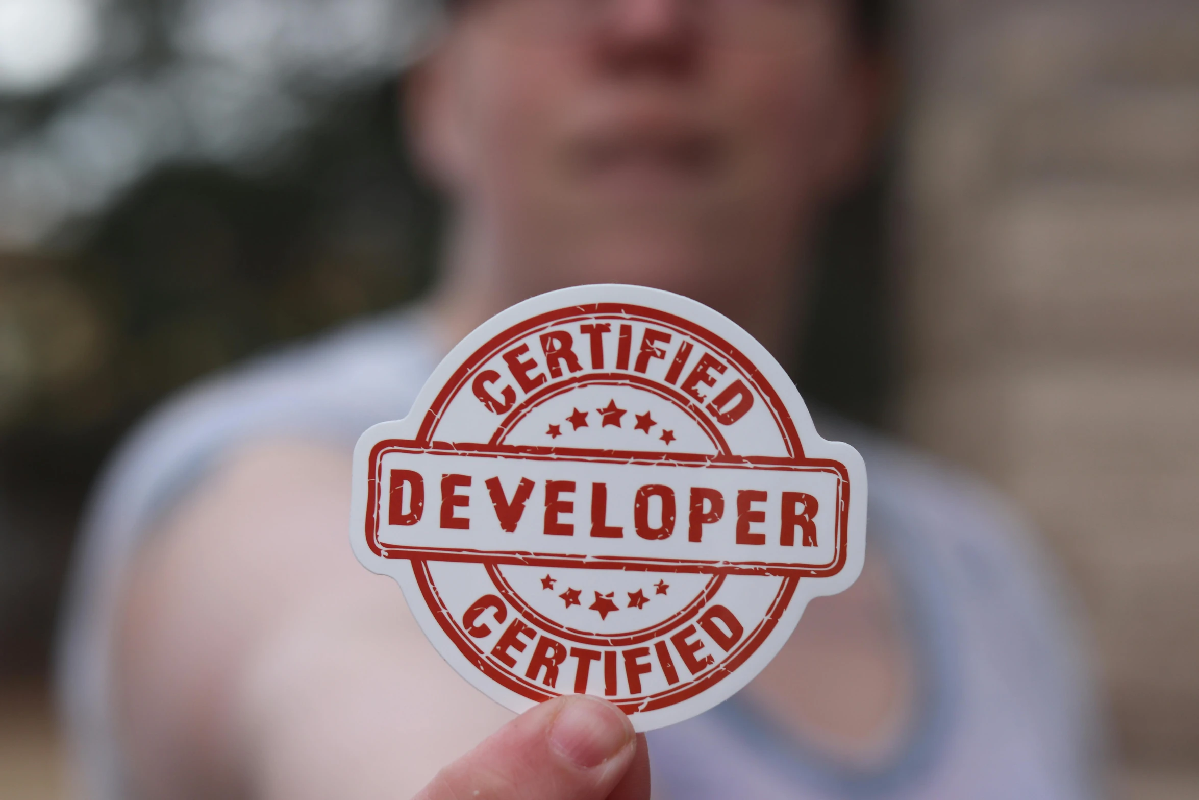 a close up of a person holding a sticker, developers, proud, female, white