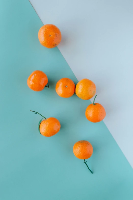 a group of oranges sitting on top of a blue and white surface