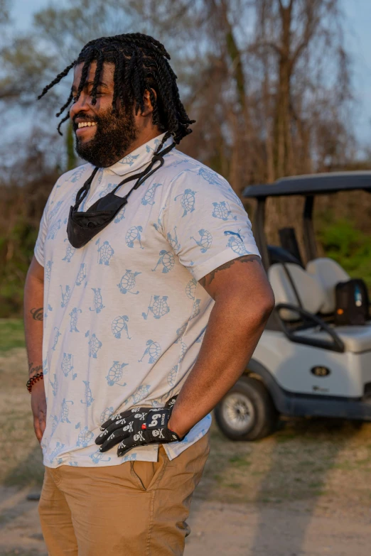 a man with dreadlocks standing next to a golf cart, open v chest clothes, wrx golf, alabama, rugged beard