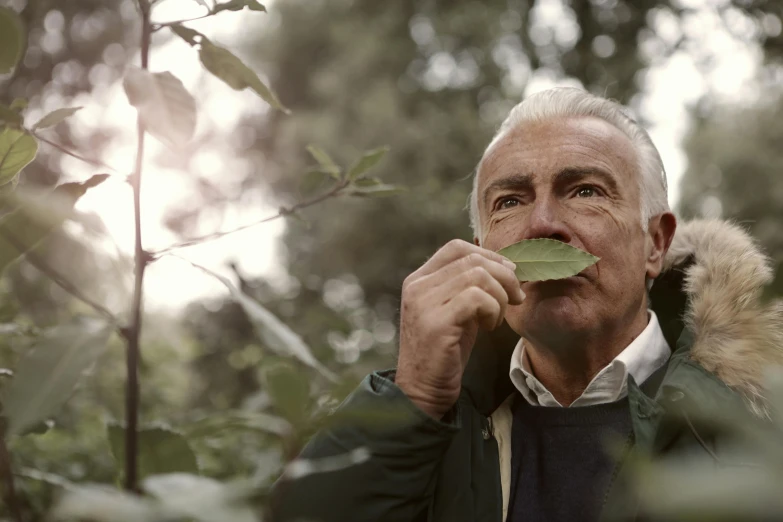 a man with a leaf in his mouth, a photo, unsplash, photorealism, still from nature documentary, delightful surroundings, shot on hasselblad, sean connery