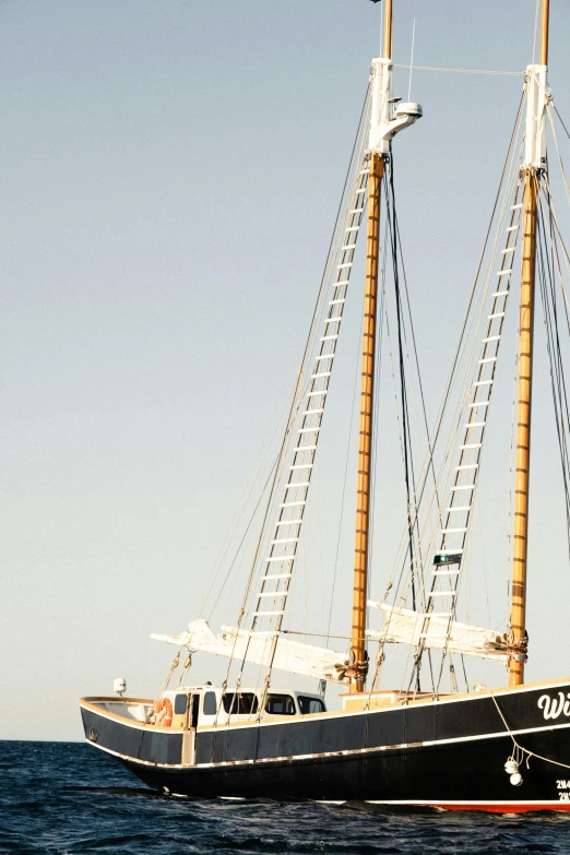 a large boat floating on top of a body of water, a portrait, three masts, taken at golden hour, upclose, july 2 0 1 1