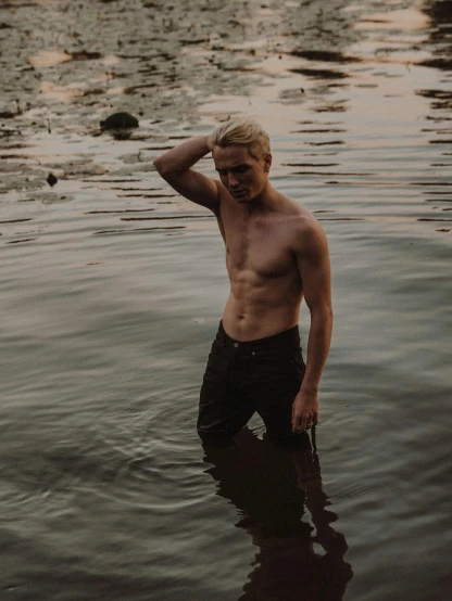 a man standing in a body of water, inspired by Elsa Bleda, pexels contest winner, renaissance, blonde guy, bare midriff, non-binary, rugged