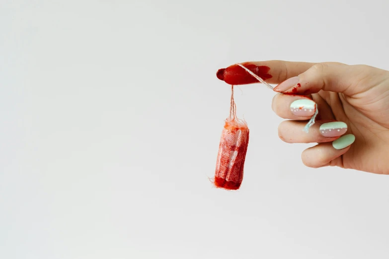 a close up of a person holding a toothbrush, inspired by Méret Oppenheim, plasticien, hanging beef carcasses, nail polish, blood drop, 2019 trending photo