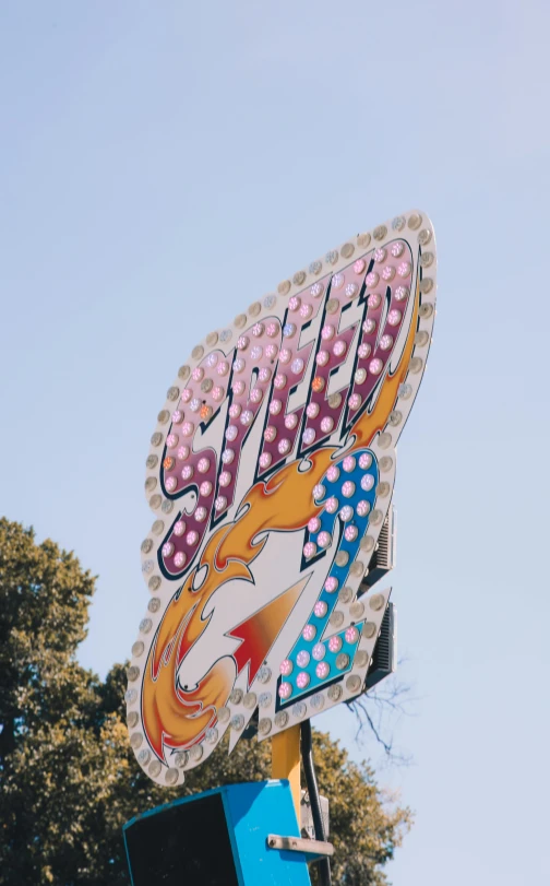 a sign that is on top of a pole, by Andrew Stevovich, unsplash, graffiti, fairground rides, soft vintage glow, profile image, bedazzled