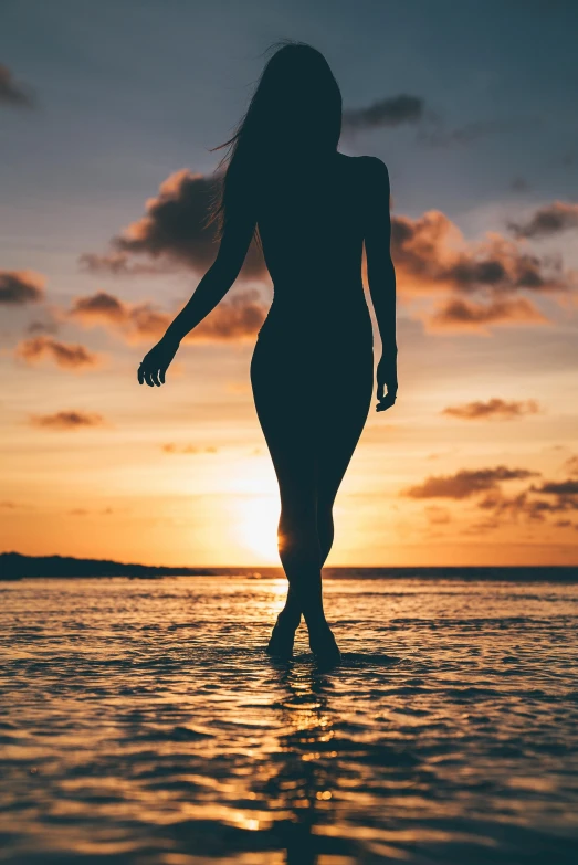 a woman standing in the water at sunset, smooth tan skin, outlined silhouettes, walking confidently, bare leg