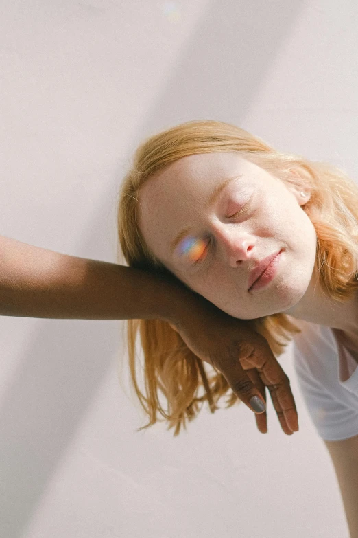 a woman laying on top of a bed with her eyes closed, by Nathalie Rattner, light and space, glowing rainbow face, woman holding another woman, ellie bamber, ignant