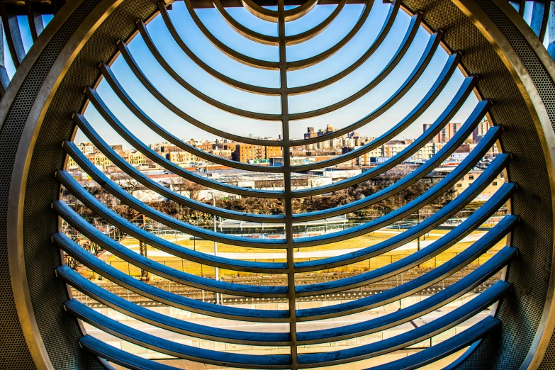 a view of a city through a circular window, by Emanuel Witz, pexels contest winner, op art, spiral horns!, museum light, panoramic shot, golden light