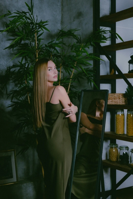 a woman standing in front of a mirror, dark blonde long hair, lush green, photo for a store, made of bamboo
