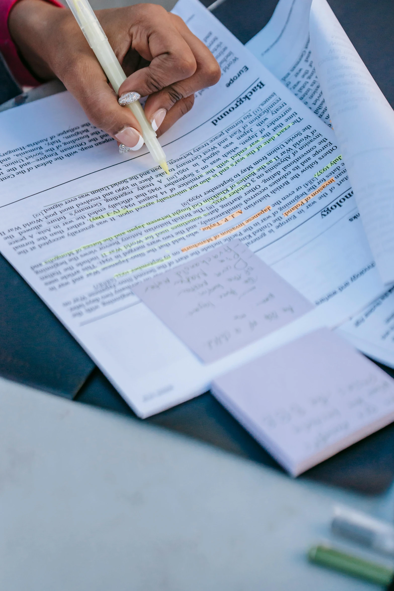 a person sitting at a table with papers and a pen, with notes, up-close, documentation, commercially ready