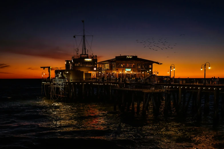 a pier at night with birds flying in the sky, by Peter Churcher, pexels contest winner, romanticism, the city of santa barbara, 2 5 6 x 2 5 6 pixels, brown, summer evening