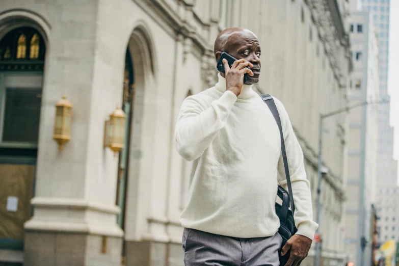 a man walking down a street talking on a cell phone, pexels contest winner, renaissance, african canadian, bald man, middle aged man, a person standing in front of a