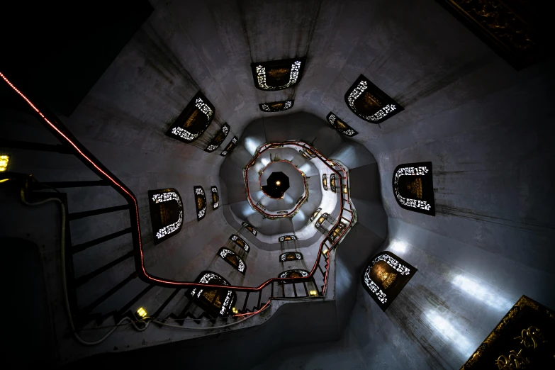 a spiral staircase in a building at night, inspired by M. C. Escher, unsplash contest winner, conceptual art, elite dangerous, cyber steampunk 8 k 3 d, overhead shot, capsule hotel