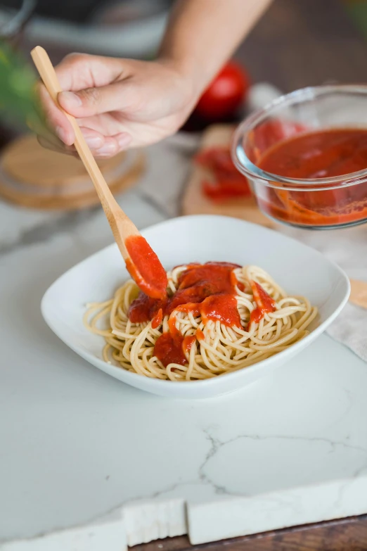 a person holding a wooden spoon over a bowl of spaghetti, extra ketchup, product image, unbeatable quality, grey