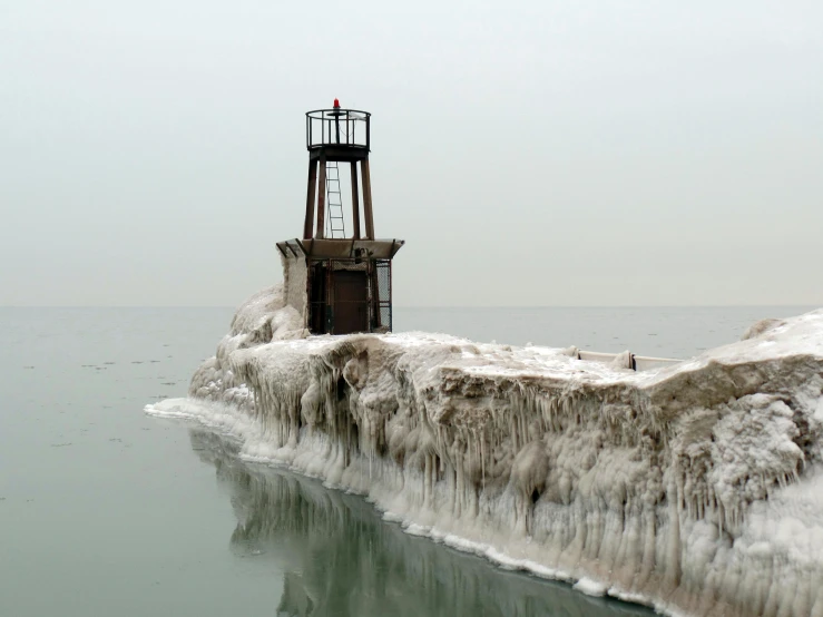 a lighthouse in the middle of a body of water, a photo, by Alison Geissler, frozen like a statue, chicago, ignant, near a jetty