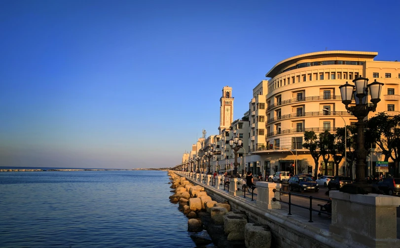 a row of buildings next to a body of water, pexels contest winner, art nouveau, alexandria\'s genesis, coastline, square, late afternoon