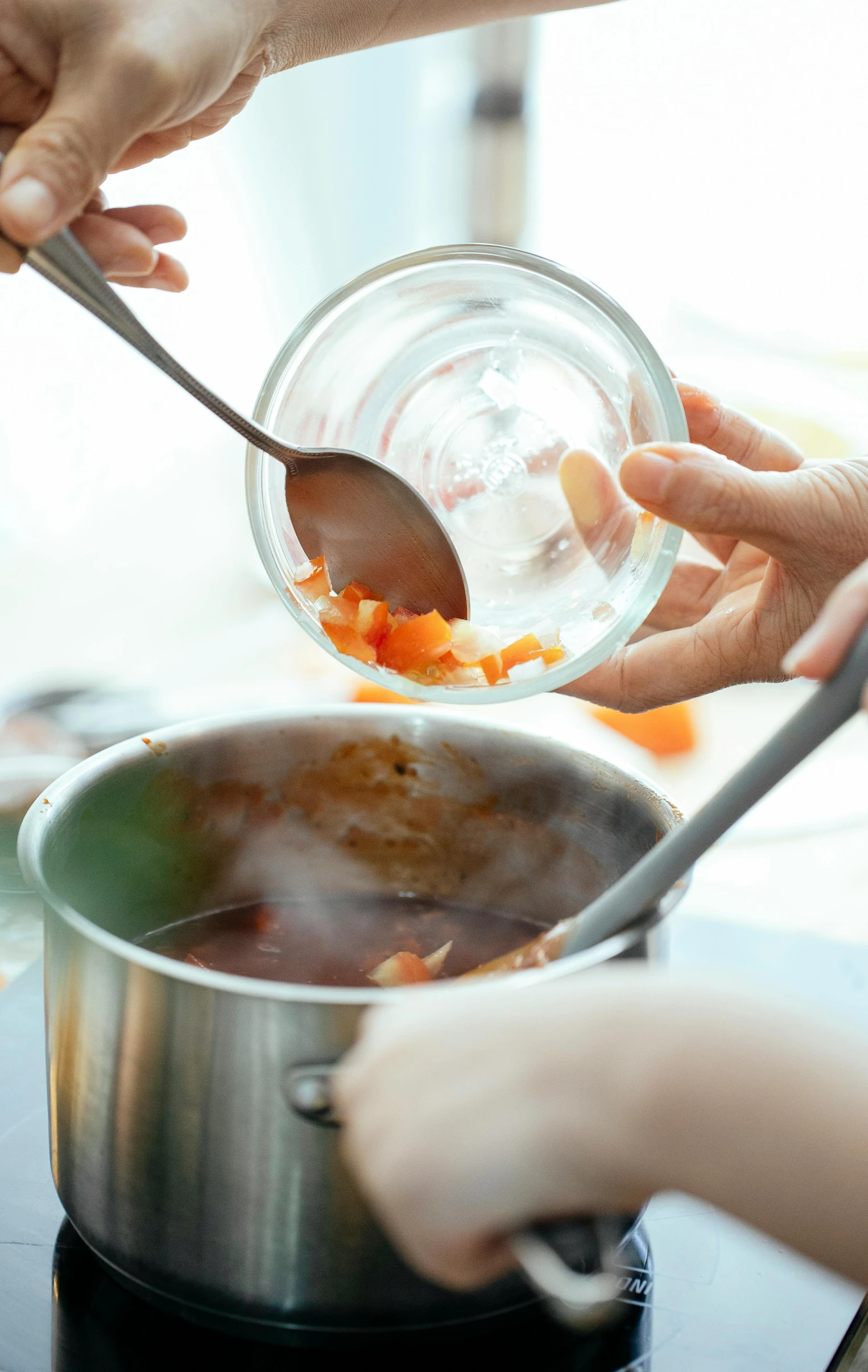 a person pouring something into a pot on a stove, pexels, process art, good soup, square, inside a glass jar, stew