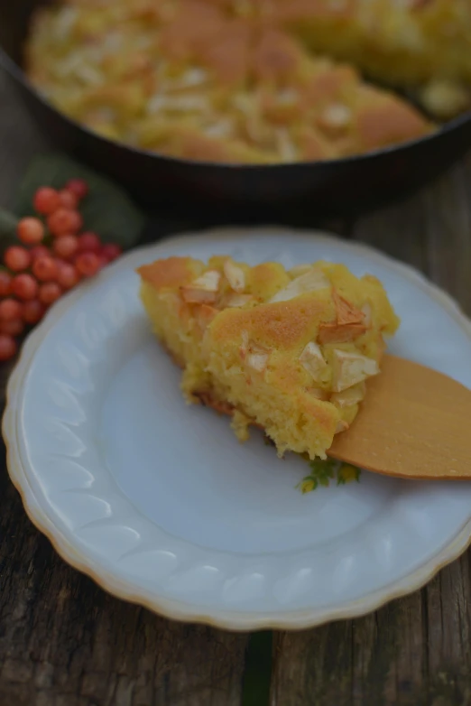 a piece of cornbread sitting on top of a white plate, a pastel, hurufiyya, yellow apples, digging, pot, rustic