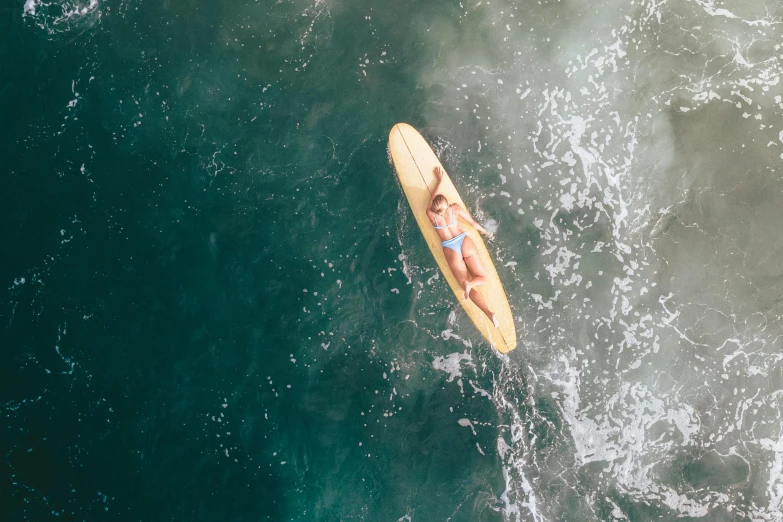 a person riding a surfboard on top of a body of water, by Carey Morris, unsplash contest winner, helicopter view, avatar image, blonde, soft glow
