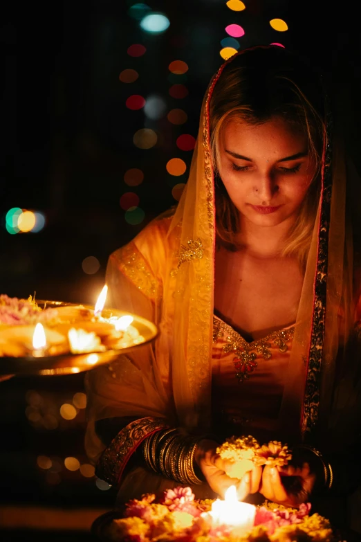 a woman holding a tray full of candles, pexels contest winner, wearing traditional garb, gold light, square, praying