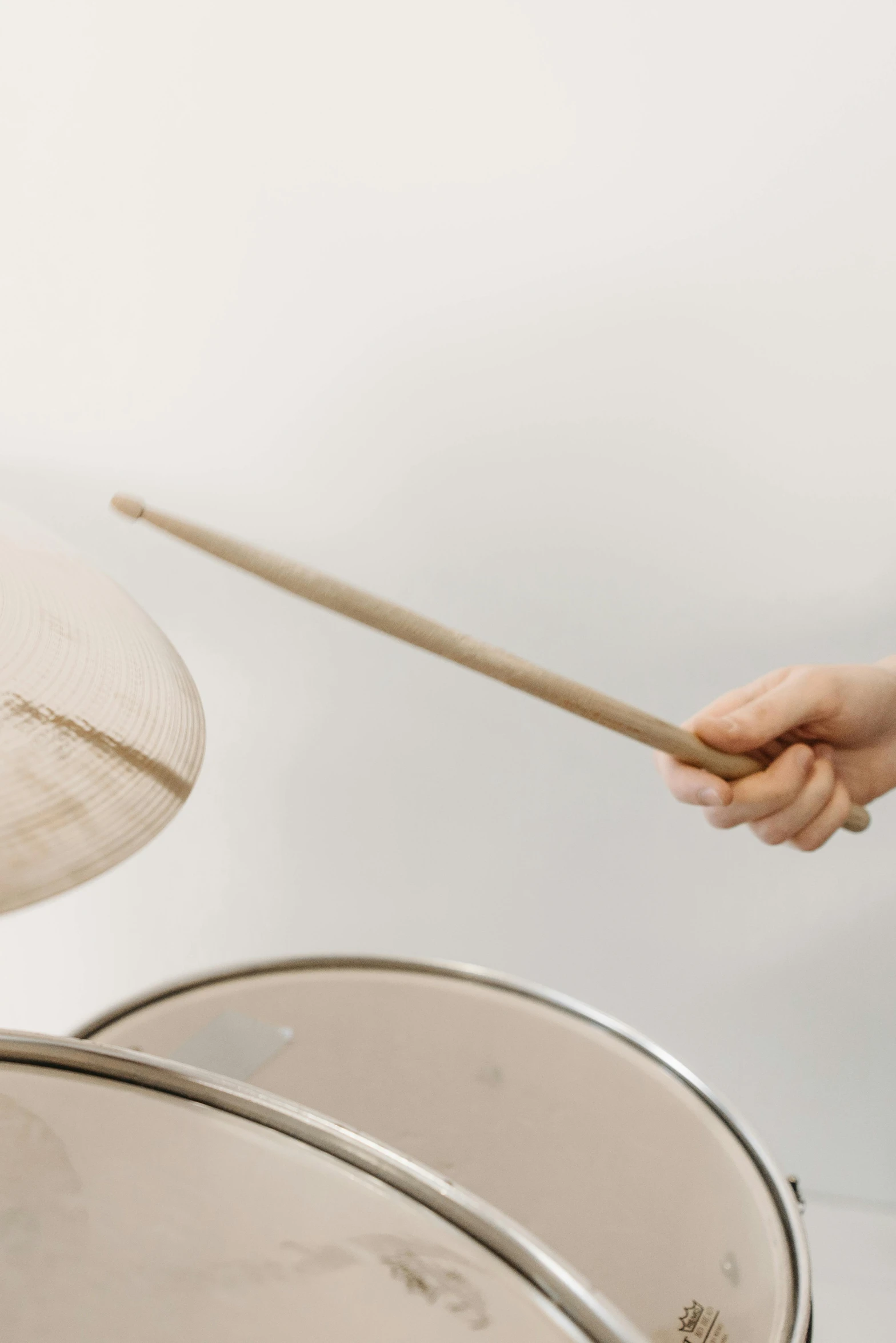 a close up of a person playing a drum, an album cover, by Gavin Hamilton, trending on unsplash, plain background, drum scanner, yoko taro, made of bamboo