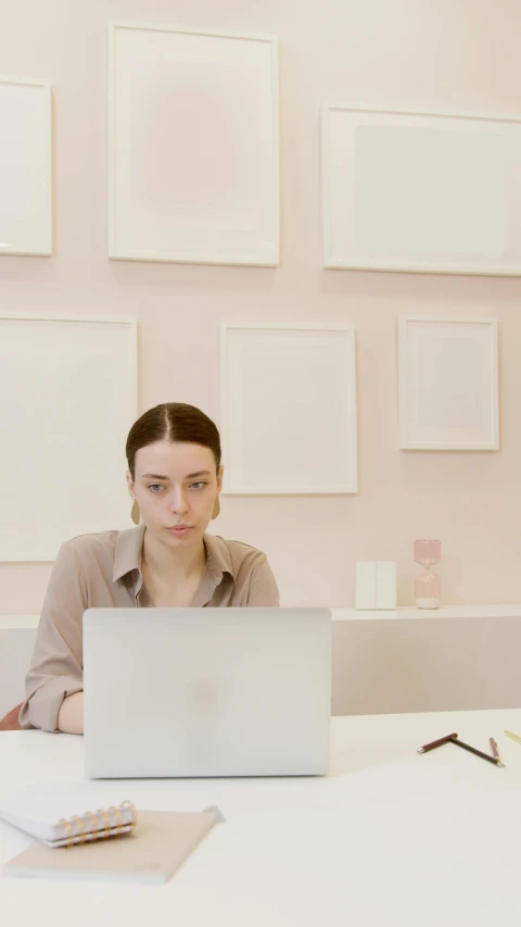 a woman sitting at a table with a laptop, by Carey Morris, trending on unsplash, computer art, minimal pink palette, in an call centre office, looking serious, in a classroom