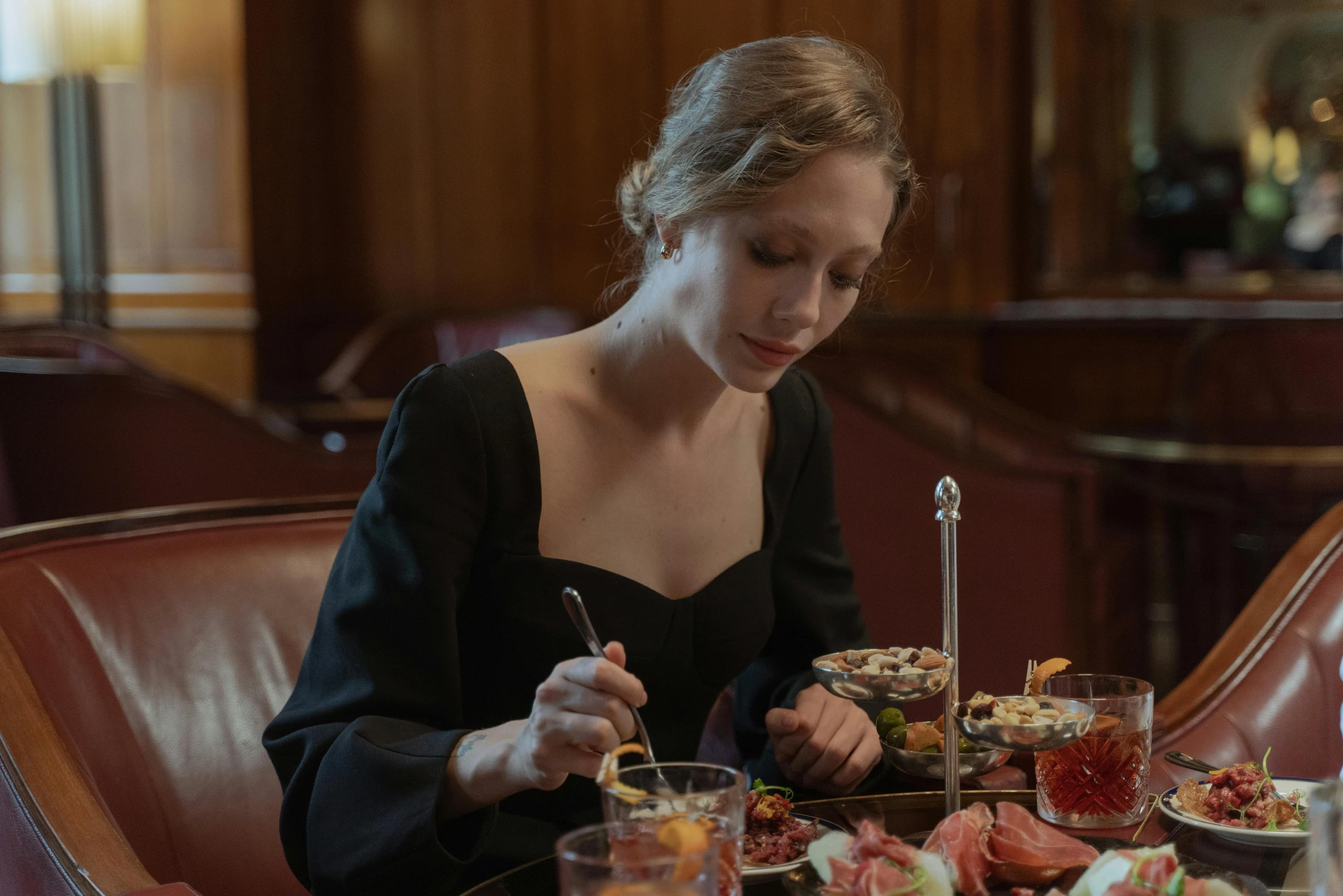 a woman sitting at a table with a plate of food, sydney sweeney, gentlemens dinner, award winning. cinematic, plating