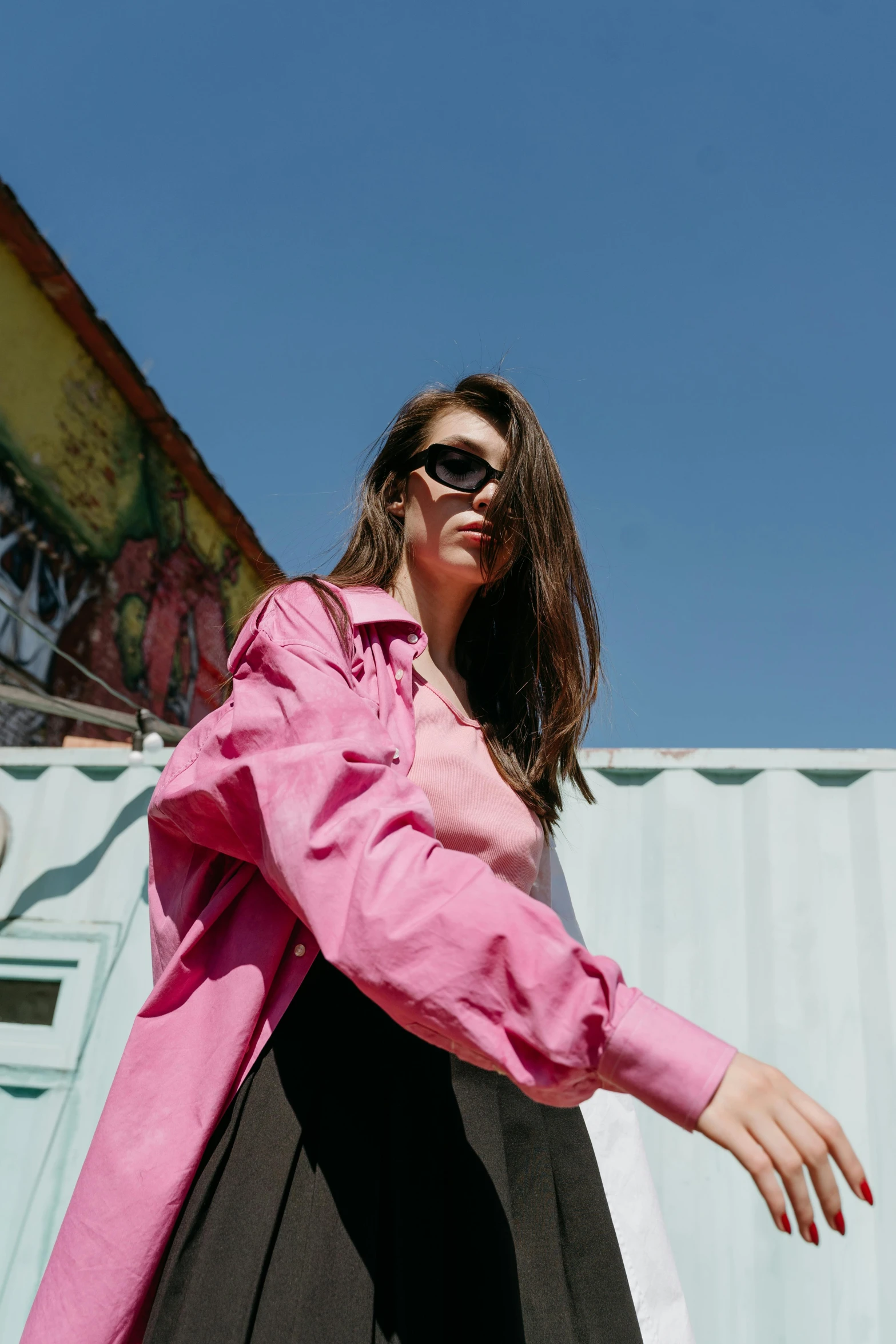 a woman in a pink shirt and black skirt, trending on pexels, graffiti, with sunglass, off - white collection, cinematic luts, bright vivid color hues:1