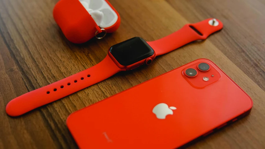 a red apple watch sitting on top of a wooden table, trending on pexels, airpods, red uniform, cell phone, orange neon