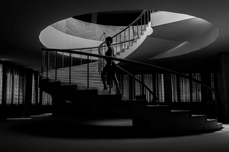 a man standing on top of a set of stairs, inspired by Jerry Schatzberg, pexels contest winner, bauhaus, dark ballerina, curved lines, in the museum, stylized silhouette