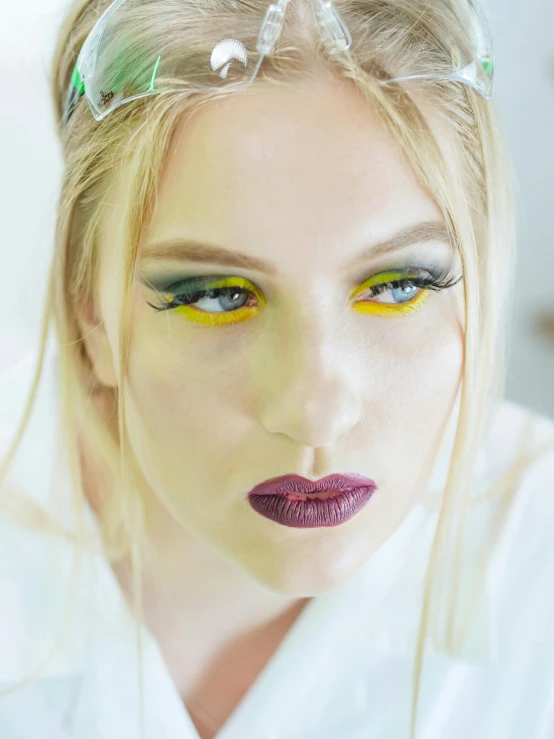 a woman in a white robe is posing for a picture, a colorized photo, inspired by Louisa Matthíasdóttir, trending on pexels, yellow makeup, dark green smokey eyeshadow, blonde crea, kefka ff6