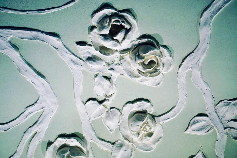 a close up of a painting of flowers on a wall, inspired by Lucio Fontana, unsplash, rococo, pale green glow, soap carving, white roses, embossed paint