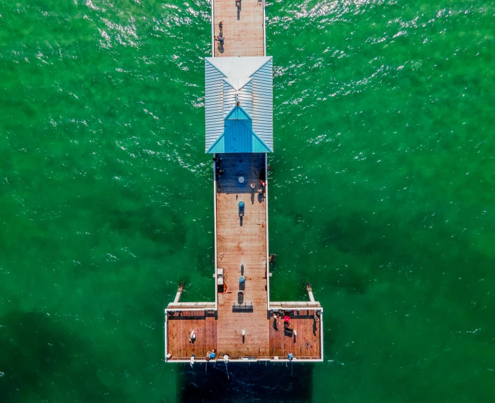a pier in the middle of a body of water, by Peter Churcher, pexels contest winner, hurufiyya, green and blue, birdeye, zac retz, mundy